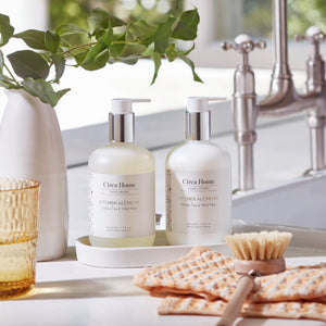 CIRCA White Tea and Wild Mint 340mL Hand Duo Set (wash and lotion on tray) sitting beside a kitchen sink
