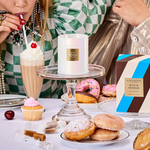 Glasshouse Fragrances Rich & Famous Iced Mocha 380g Soy Candle burning on a spread of sweet baked goods and shakes